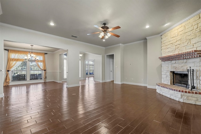 unfurnished living room featuring ornamental molding, dark wood-type flooring, ceiling fan with notable chandelier, and a fireplace