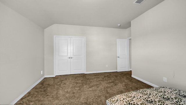 carpeted bedroom with vaulted ceiling and a closet