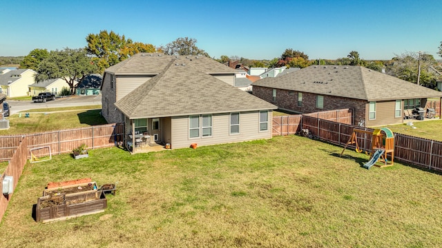 rear view of house with a playground and a yard