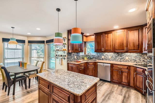 kitchen with light wood-type flooring, backsplash, decorative light fixtures, dishwasher, and a kitchen island