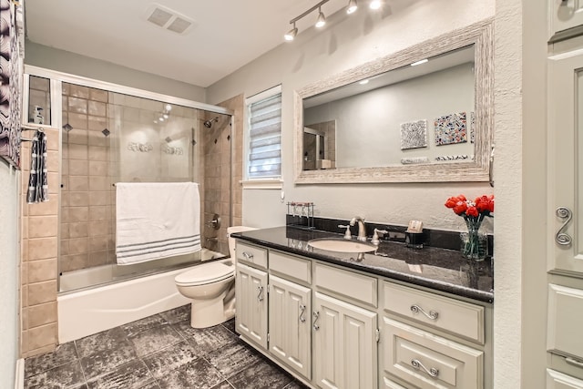 full bathroom featuring vanity, toilet, and enclosed tub / shower combo