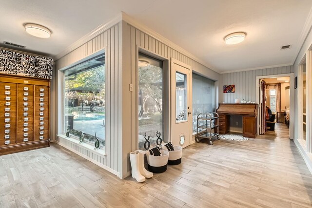 entryway with hardwood / wood-style floors and crown molding