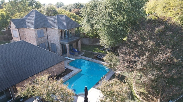 view of swimming pool with a diving board and a patio