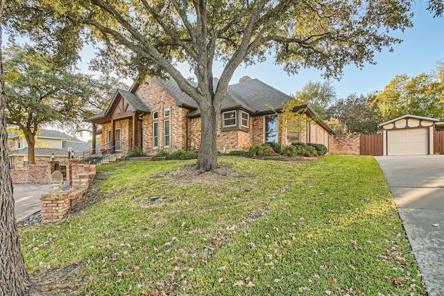 view of front facade featuring a garage, an outdoor structure, and a front lawn