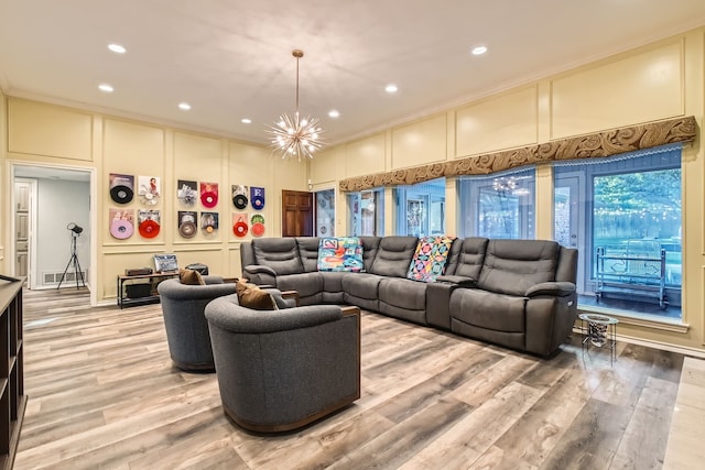 living room with a chandelier, light wood-type flooring, and crown molding