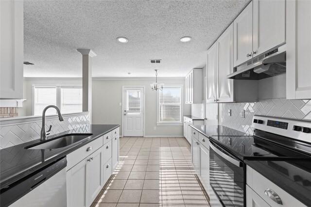 kitchen featuring appliances with stainless steel finishes, light tile patterned floors, white cabinetry, and sink