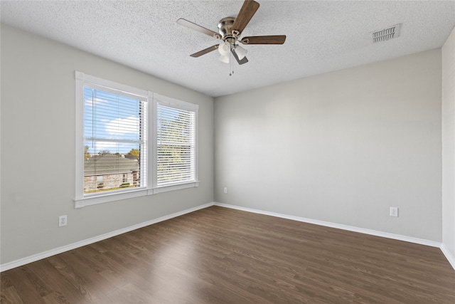 unfurnished room with a textured ceiling, ceiling fan, and dark wood-type flooring