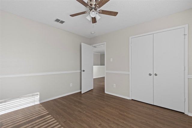 unfurnished bedroom featuring a closet, ceiling fan, and dark wood-type flooring