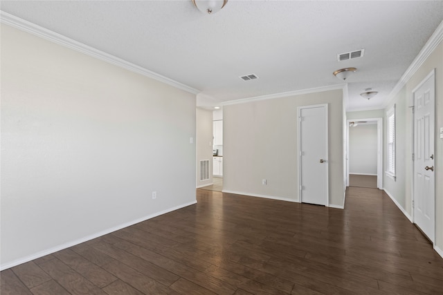 empty room featuring crown molding and dark wood-type flooring