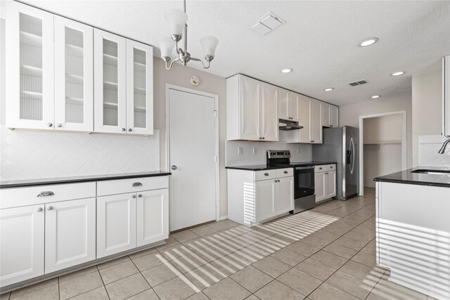 kitchen with sink, white cabinets, a notable chandelier, light tile patterned floors, and appliances with stainless steel finishes