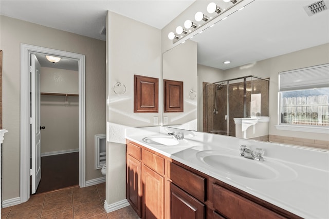 bathroom featuring tile patterned flooring, vanity, and walk in shower