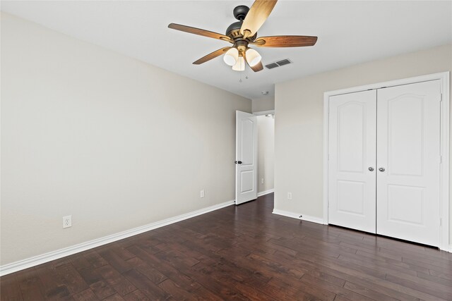 unfurnished bedroom featuring a closet, ceiling fan, and dark wood-type flooring