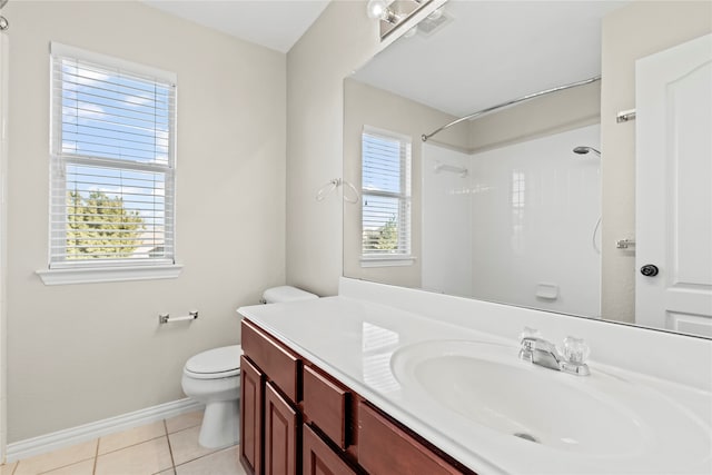 bathroom featuring tile patterned flooring, toilet, a wealth of natural light, and walk in shower