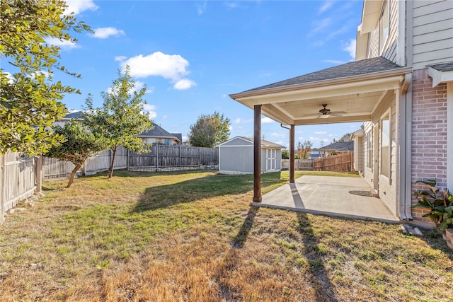 view of yard featuring a patio, ceiling fan, and a storage shed