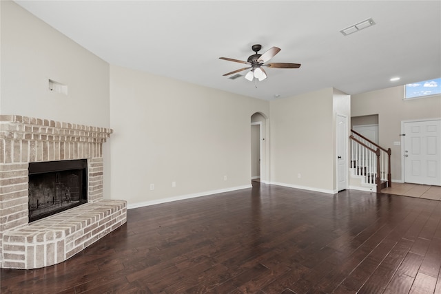 unfurnished living room featuring a fireplace, ceiling fan, and dark wood-type flooring