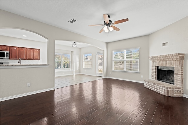 unfurnished living room featuring hardwood / wood-style floors, a healthy amount of sunlight, and a fireplace