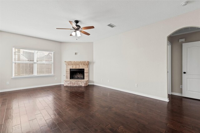 unfurnished living room featuring dark hardwood / wood-style floors, ceiling fan, and a fireplace