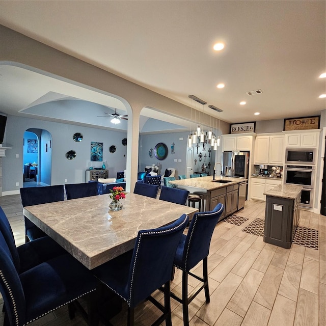 dining room with ceiling fan and sink