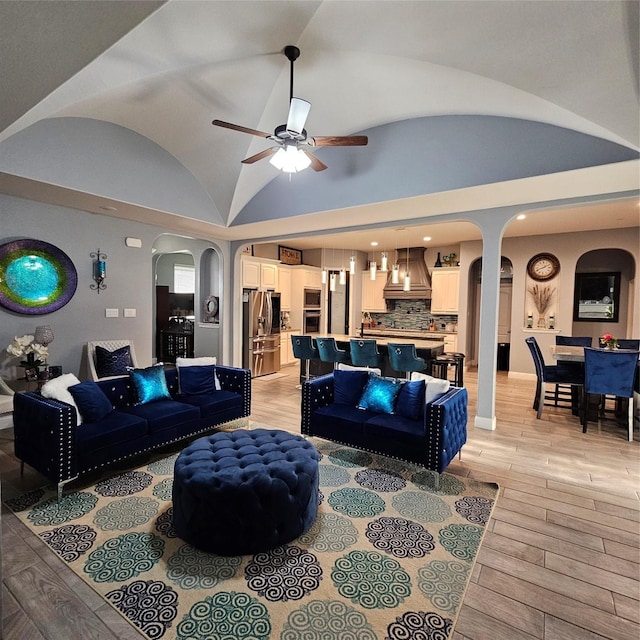 living room featuring vaulted ceiling, ceiling fan, and light hardwood / wood-style floors