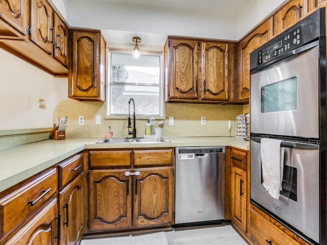 kitchen featuring decorative backsplash, sink, and appliances with stainless steel finishes