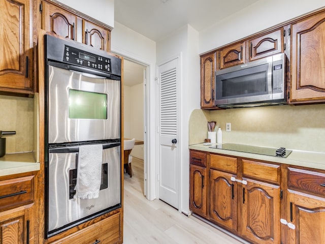 kitchen with stainless steel appliances and light hardwood / wood-style flooring