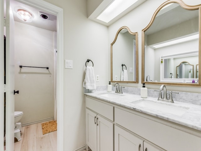 bathroom featuring hardwood / wood-style floors, vanity, and toilet