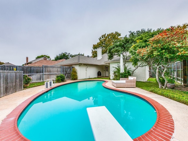 view of swimming pool featuring a diving board