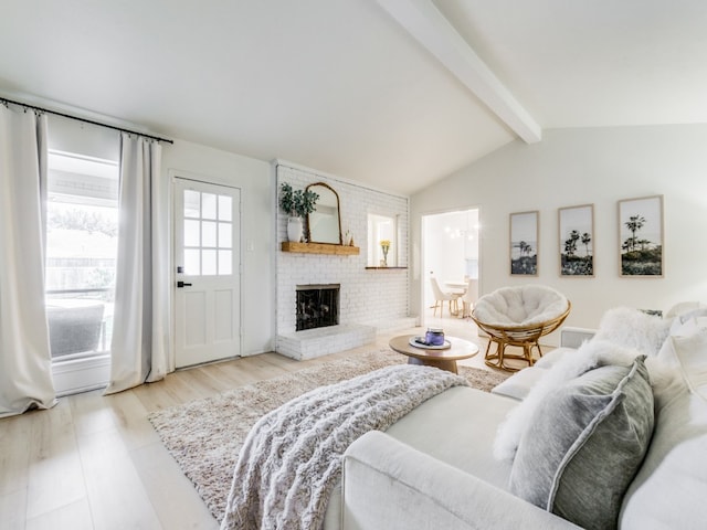 living room featuring vaulted ceiling with beams, a fireplace, and light wood-type flooring