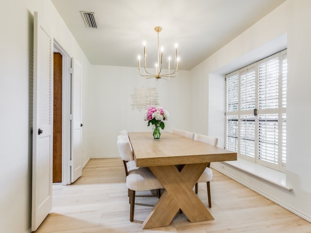 dining area featuring a notable chandelier and light wood-type flooring