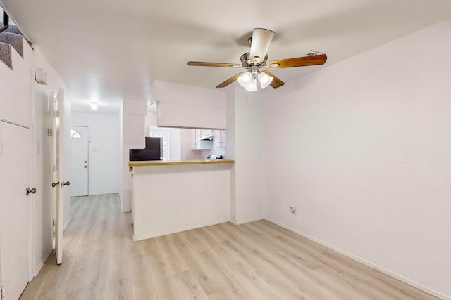 unfurnished living room featuring ceiling fan and light wood-type flooring