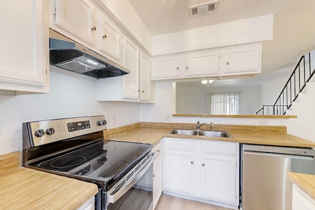 kitchen featuring white cabinetry, sink, stainless steel appliances, and light wood-type flooring