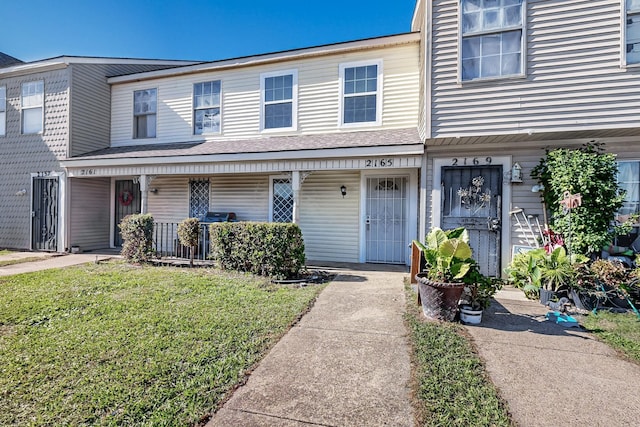 view of property with a porch and a front lawn