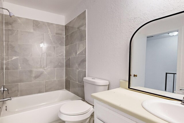 full bathroom with toilet, vanity, and tiled shower / bath