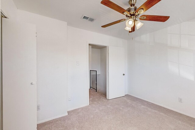 carpeted empty room featuring ceiling fan