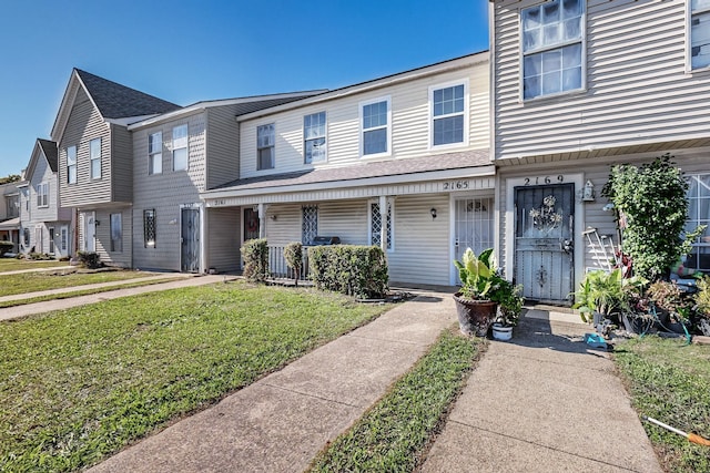 multi unit property with covered porch and a front lawn