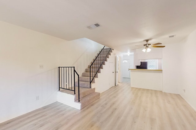 unfurnished living room featuring ceiling fan and light wood-type flooring