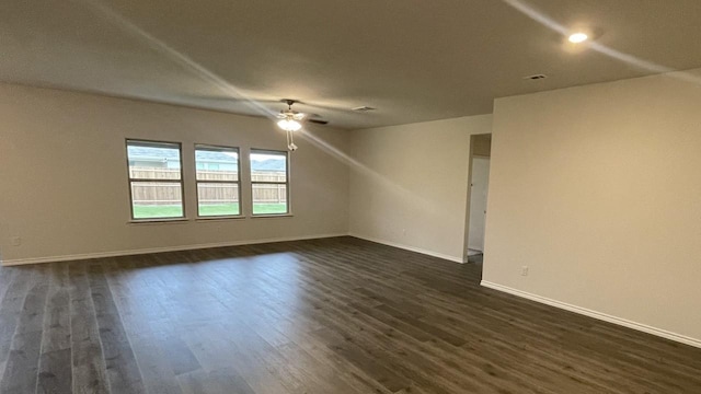 empty room with ceiling fan and dark wood-type flooring