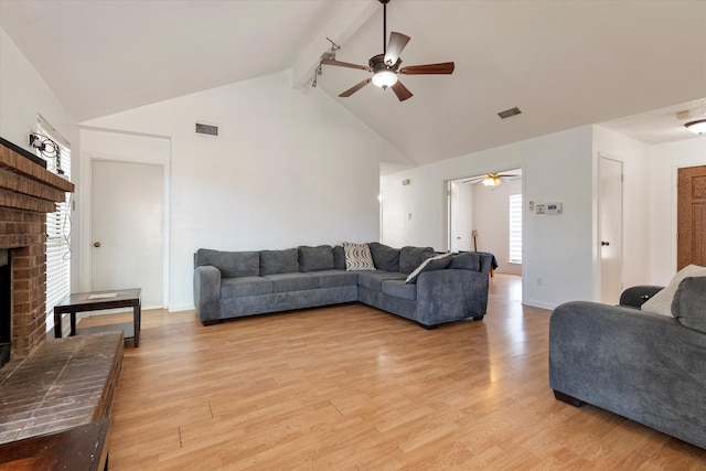 living room featuring beam ceiling, a wealth of natural light, ceiling fan, and light hardwood / wood-style floors