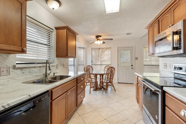 kitchen featuring appliances with stainless steel finishes, tasteful backsplash, ceiling fan, and a healthy amount of sunlight