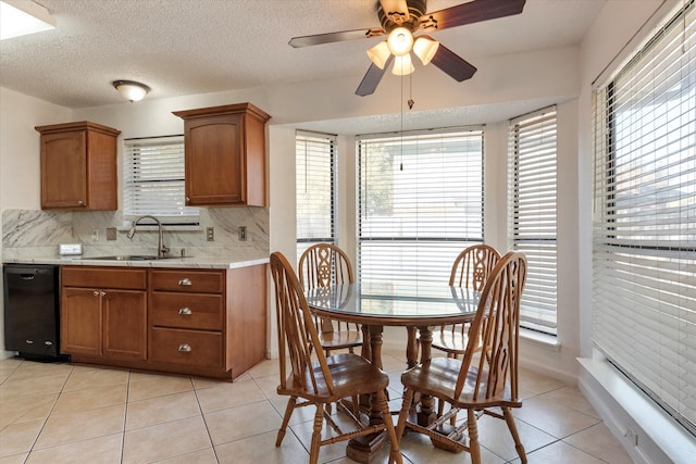 dining room featuring a textured ceiling, ceiling fan, light tile patterned floors, and sink