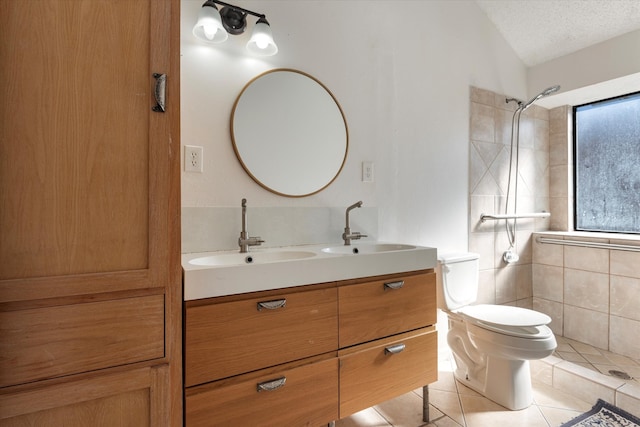 bathroom featuring vanity, a textured ceiling, vaulted ceiling, tile patterned flooring, and toilet