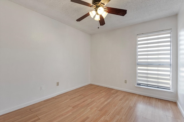 empty room featuring ceiling fan, a textured ceiling, and light wood-type flooring