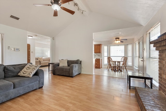 living room with rail lighting, light hardwood / wood-style flooring, ceiling fan, and lofted ceiling