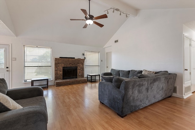 living room with ceiling fan, high vaulted ceiling, beamed ceiling, a fireplace, and hardwood / wood-style floors