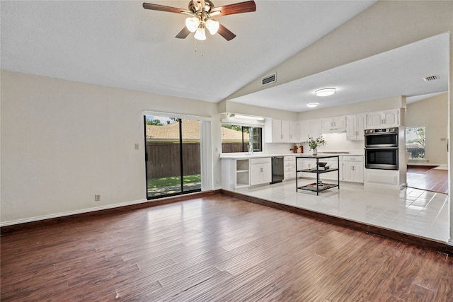 kitchen with white cabinetry, dishwasher, double oven, lofted ceiling, and hardwood / wood-style flooring