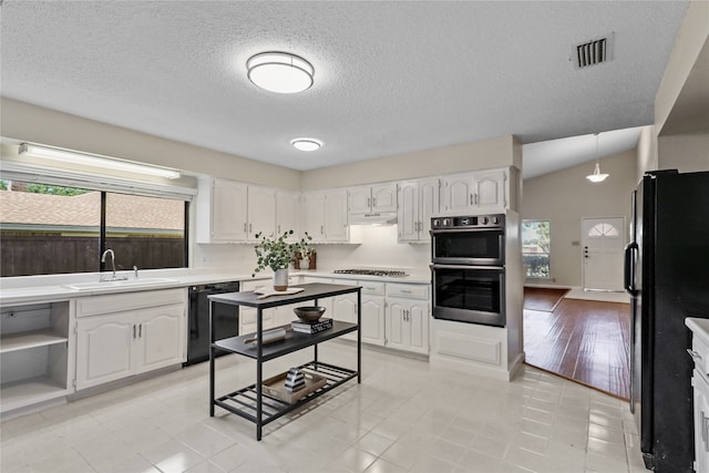 kitchen with black appliances, decorative light fixtures, a healthy amount of sunlight, and white cabinets