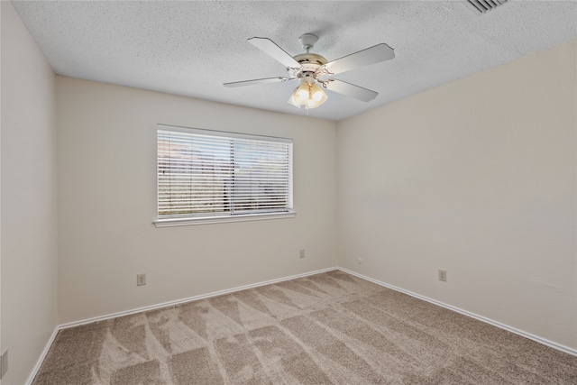 carpeted spare room featuring a textured ceiling and ceiling fan