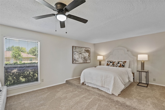 bedroom featuring light carpet, a textured ceiling, and ceiling fan