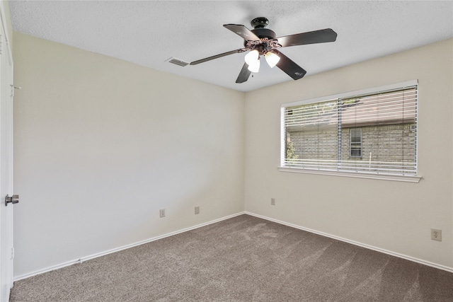 carpeted empty room with ceiling fan and a textured ceiling