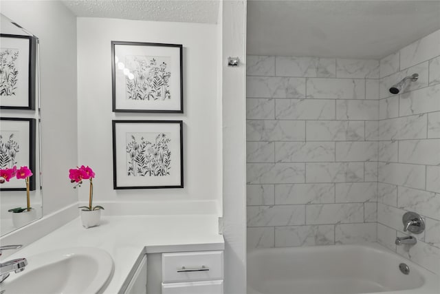 bathroom featuring a textured ceiling, vanity, and tiled shower / bath combo